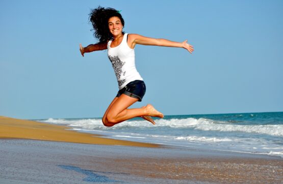 Une femme saute de joie sur la plage