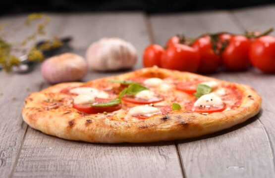pizza sur la table avec des tomates et des ingredients