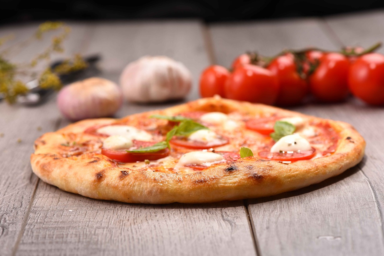pizza sur la table avec des tomates et des ingredients